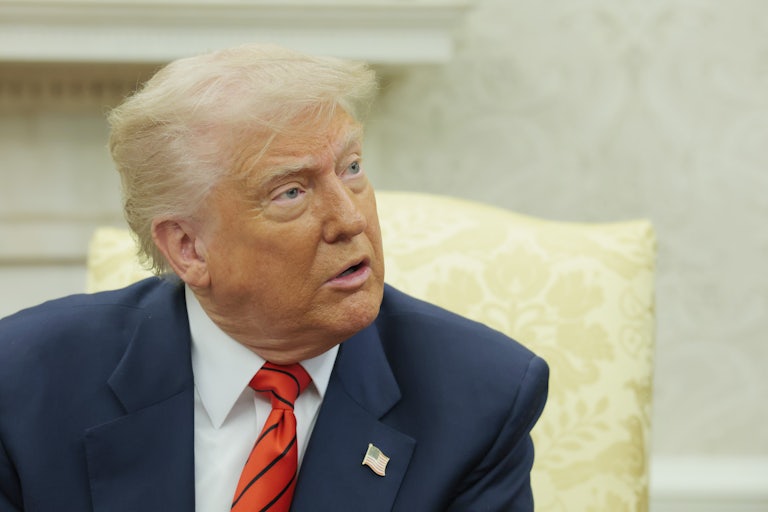 Donald Trump looks up while sitting in the Oval Office