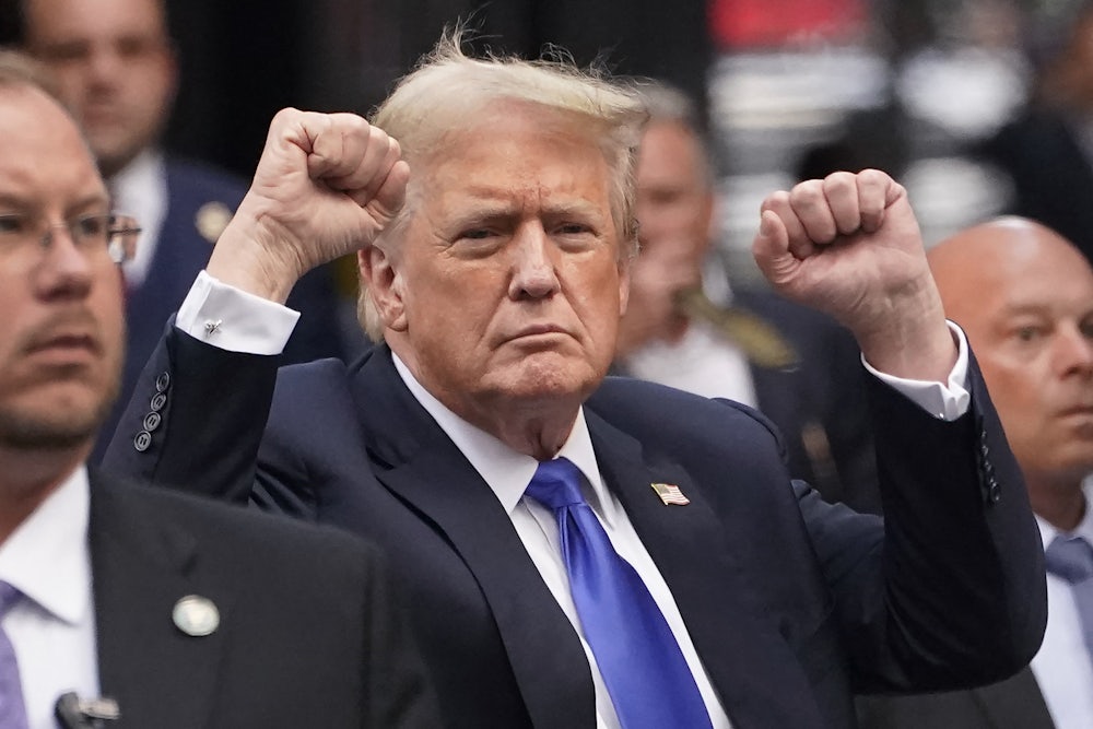 Trump raises both fists.