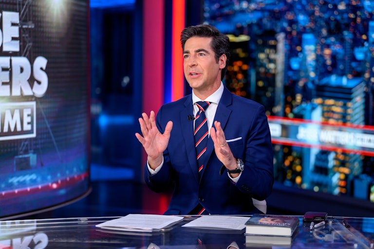 Jesse Watters sits at a desk, talking and gesturing with his hands