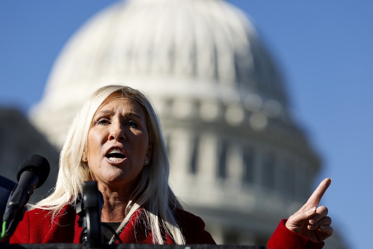 Marjorie Taylor Greene speaks outside the Capitol and raises an index finger for emphasis