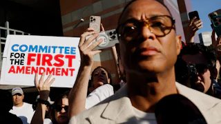 Don Lemon in front of a sign reading Committee for the First Amendment