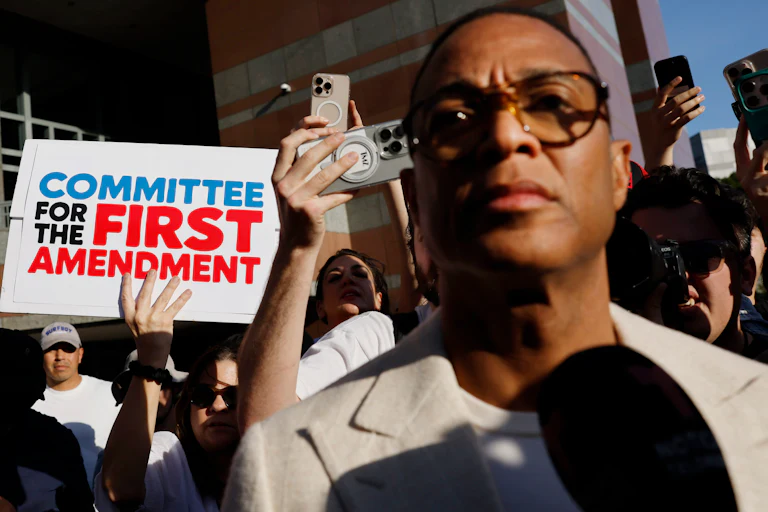Don Lemon in front of a sign reading Committee for the First Amendment
