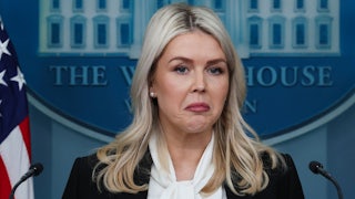 White House press secretary Karoline Leavitt frowns while standing at the podium in the press briefing room