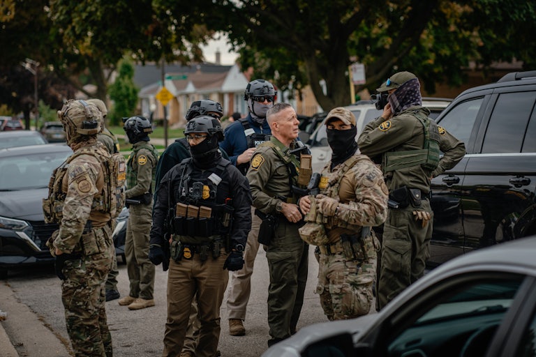 Customs and Border Patrol agents stand in a Chicago neighborhood