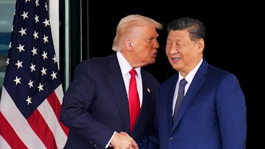 Donald Trump speaks into Chinese President Xi Jinping's ear as they shake hands