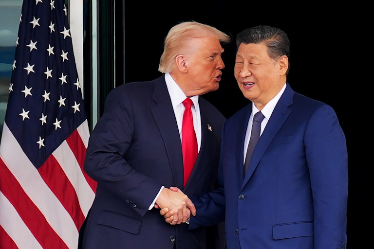 Donald Trump speaks into Chinese President Xi Jinping's ear as they shake hands