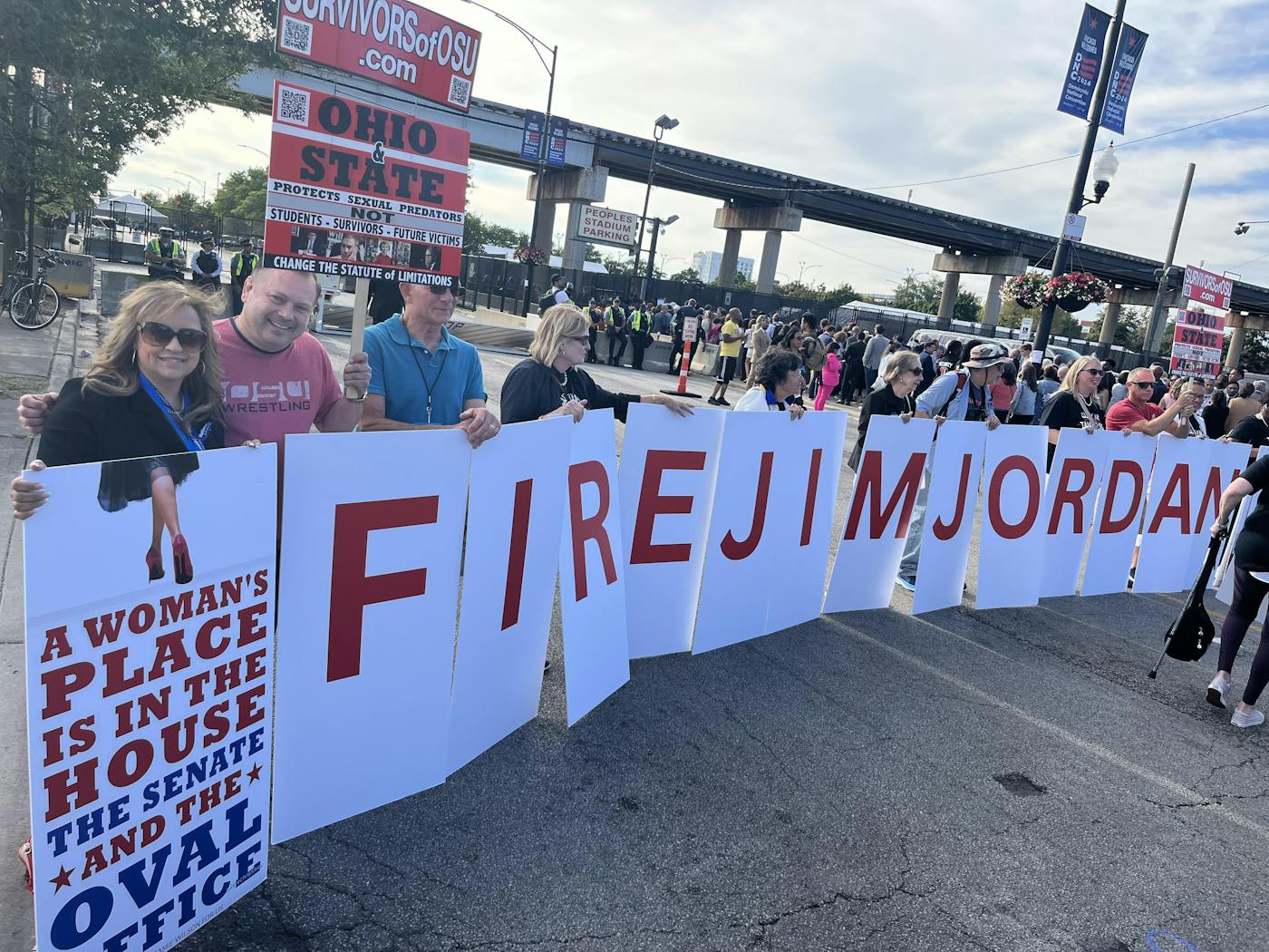 People hold up signs that say “Fire Jim Jordan”