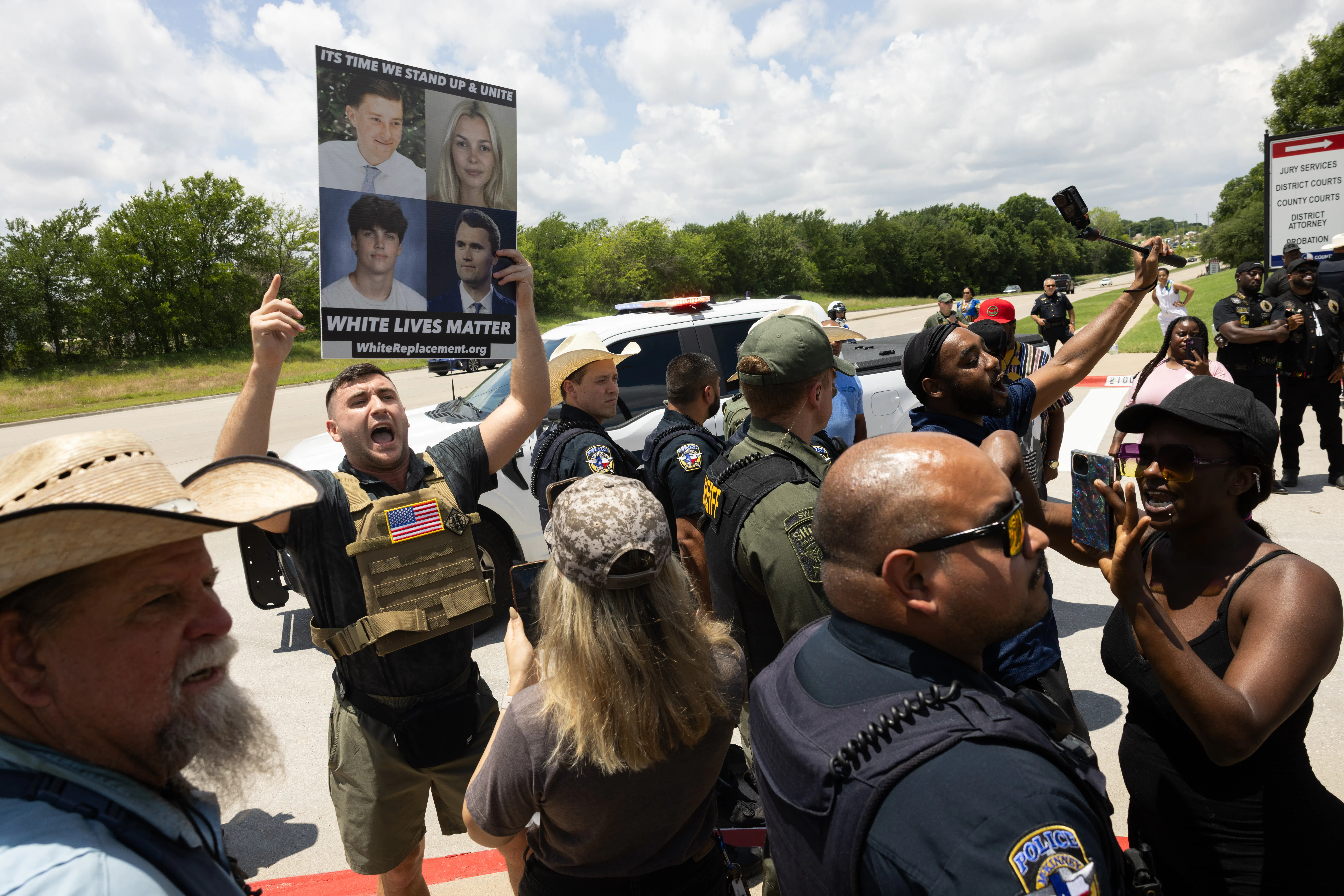 Pardoned January 6 rioter Jake Lang holds a sign that reads White Lives Matter while in a crowd outside the Collin County Courthouse.