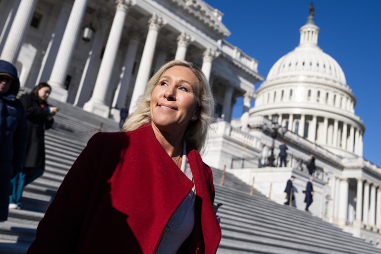 Marjorie Taylor Greene smiles while walking outside the Capitol