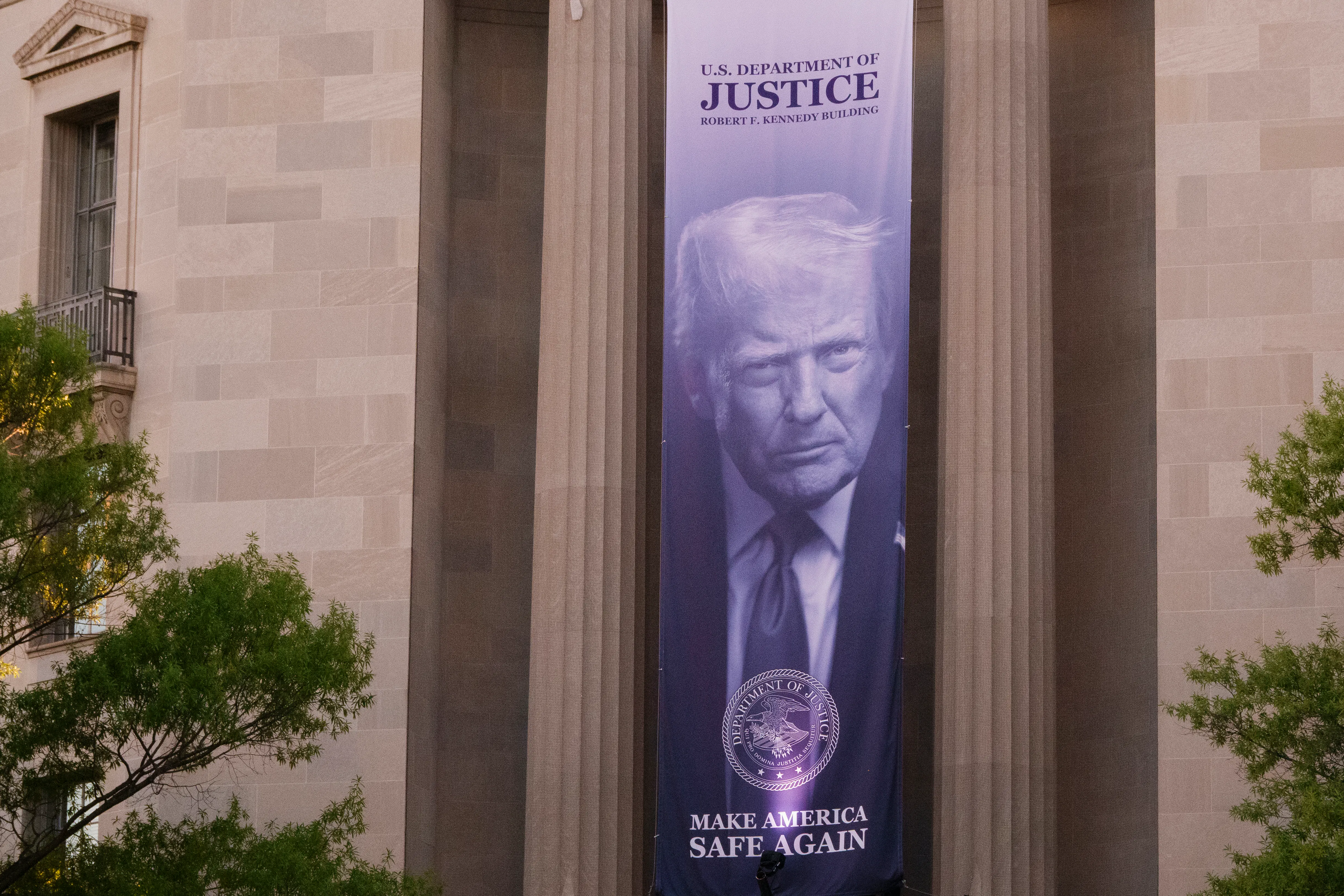 A banner of Donald Trump's face hangs from the Department of Justice building