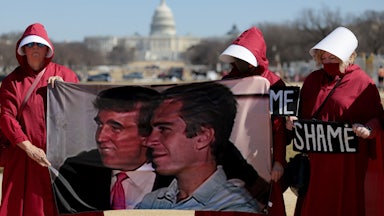 Protesters dressed as handmaids hold up a photo of Donald Trump and Jeffrey Epstein and signs that say, "SHAME" outside the White House