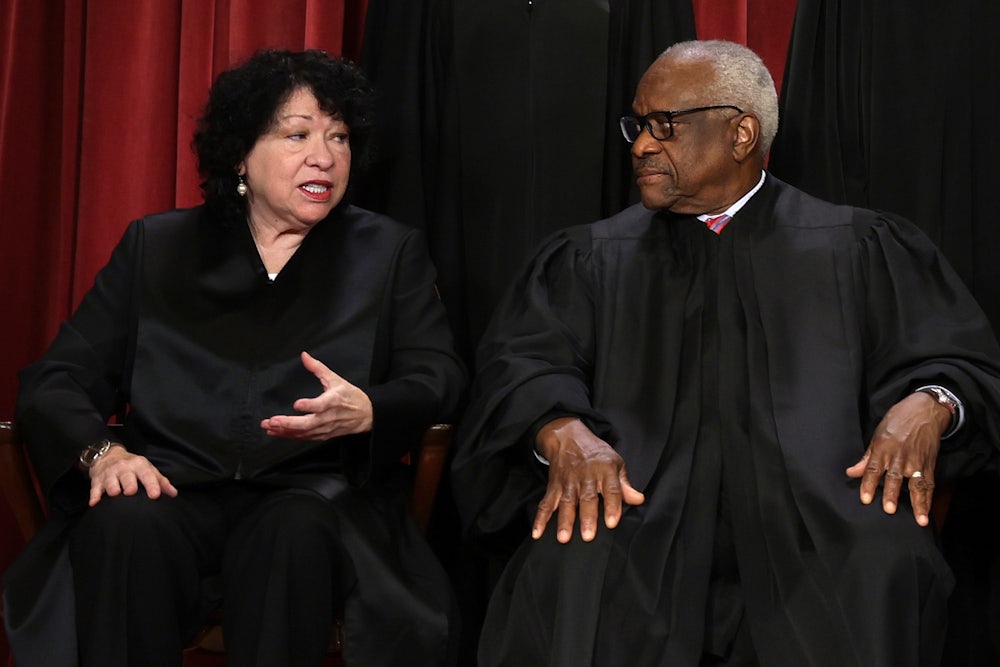 Justice Sotomayor turns to her left, talking to Clarence Thomas, while gesticulating.
