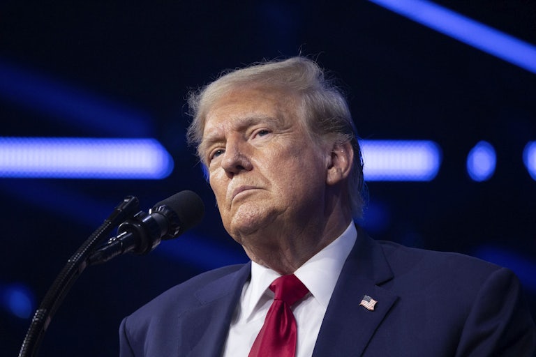 Donald Trump stands at a microphone