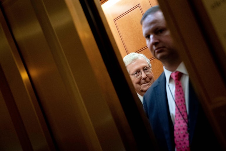 Senate Majority Leader Mitch McConnell departs on an elevator.