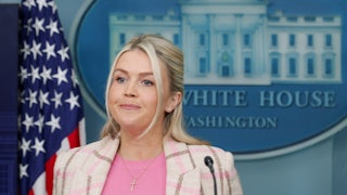 White House press secretary Karoline Leavitt presses her lips together while standing during a press briefing