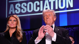 Donald Trump applauds while standing next to Melania Trump at the White House Correspondents’ Association Dinner