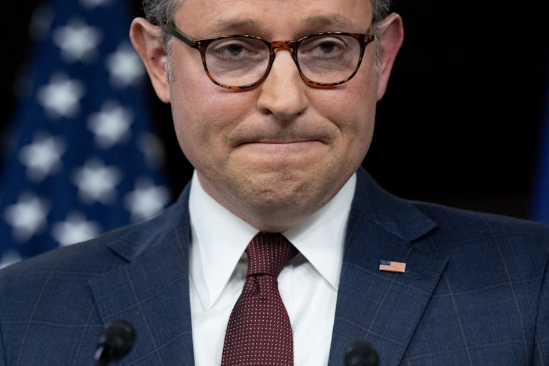 House Speaker Mike Johnson presses his lips together during a press conference