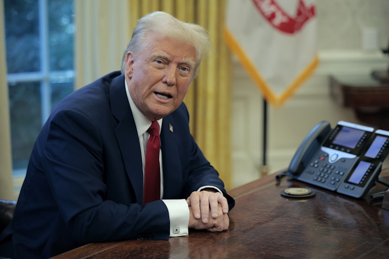 Donald Trump speaking at his desk in the Oval Office of the White House.