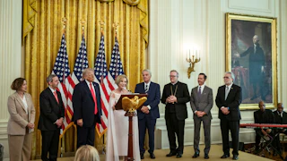 Paula Cain-White speaks at the White House Easter lunch on stage with several others, including President Trump.