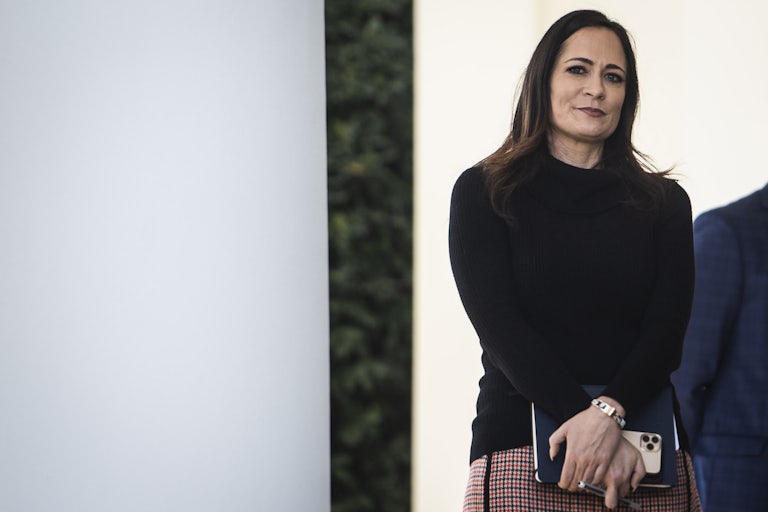 Stephanie Grisham watches Donald Trump during a press conference
