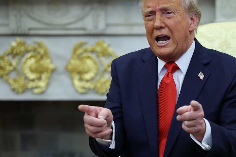 Donald Trump points and speaks while sitting in the Oval Office