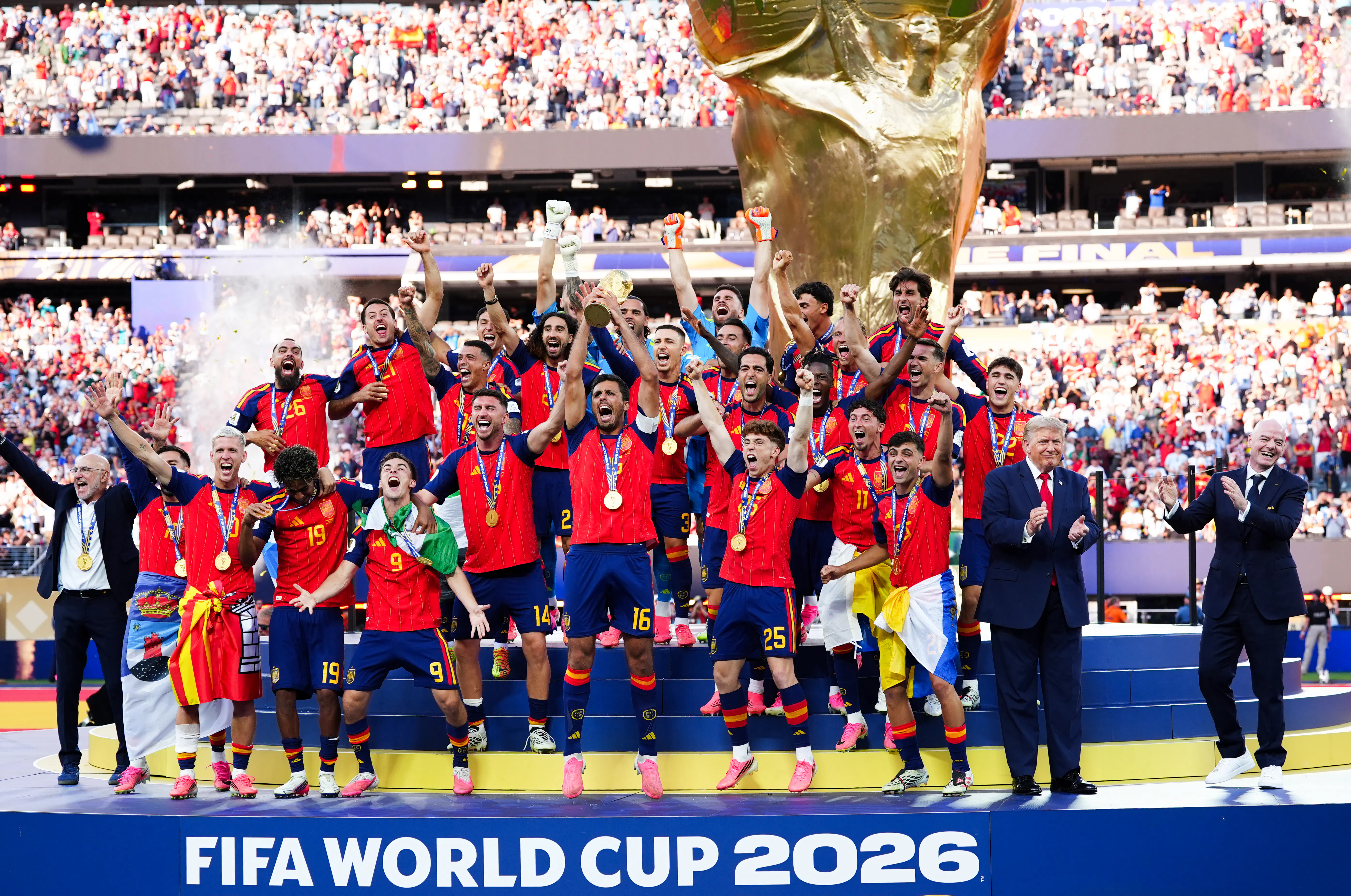 Donald Trump stands on stage next to Spain’s team as they celebrate their World Cup victory.