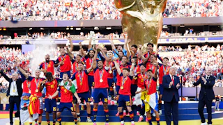 Donald Trump stands on stage next to Spain’s team as they celebrate their World Cup victory.