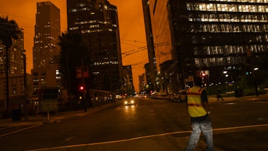 Downtown San Francisco is seen under an orange sky.