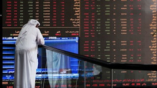A Kuwaiti trader checks stock prices at Boursa Kuwait