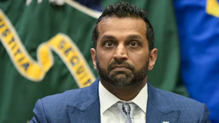 FBI Director Kash Patel sits at a table during an event