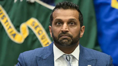 FBI Director Kash Patel sits at a table during an event