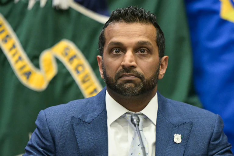 FBI Director Kash Patel sits at a table during an event