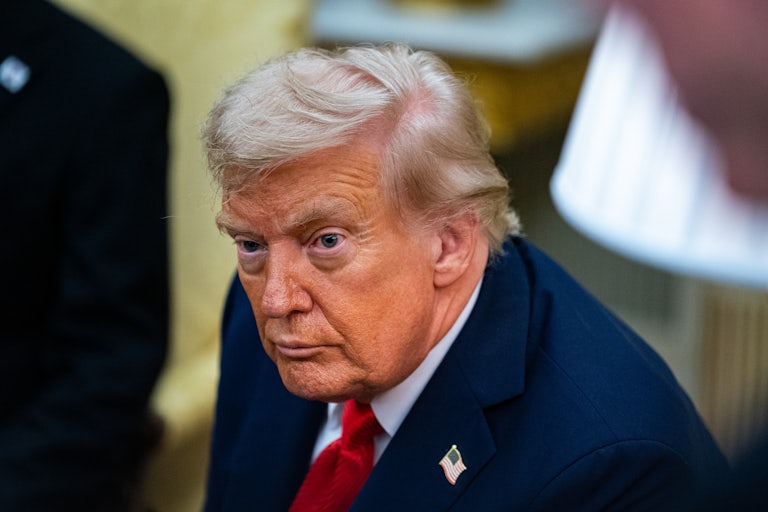 President Donald Trump sits in a press conference.