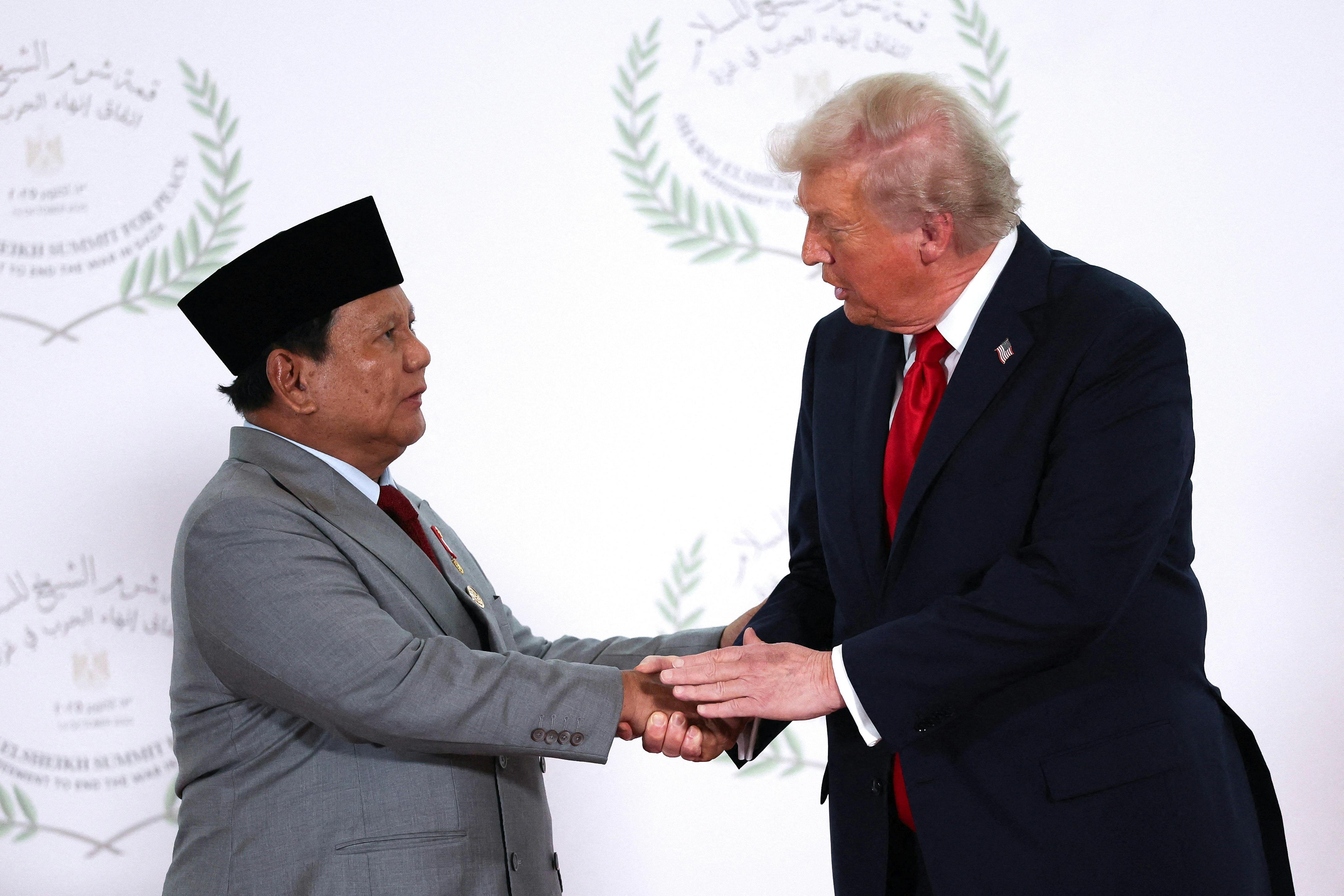 Donald Trump and Indonesian President Prabowo Subianto shake hands.