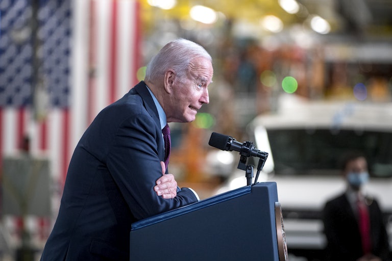 Joe Biden leans into a lectern.