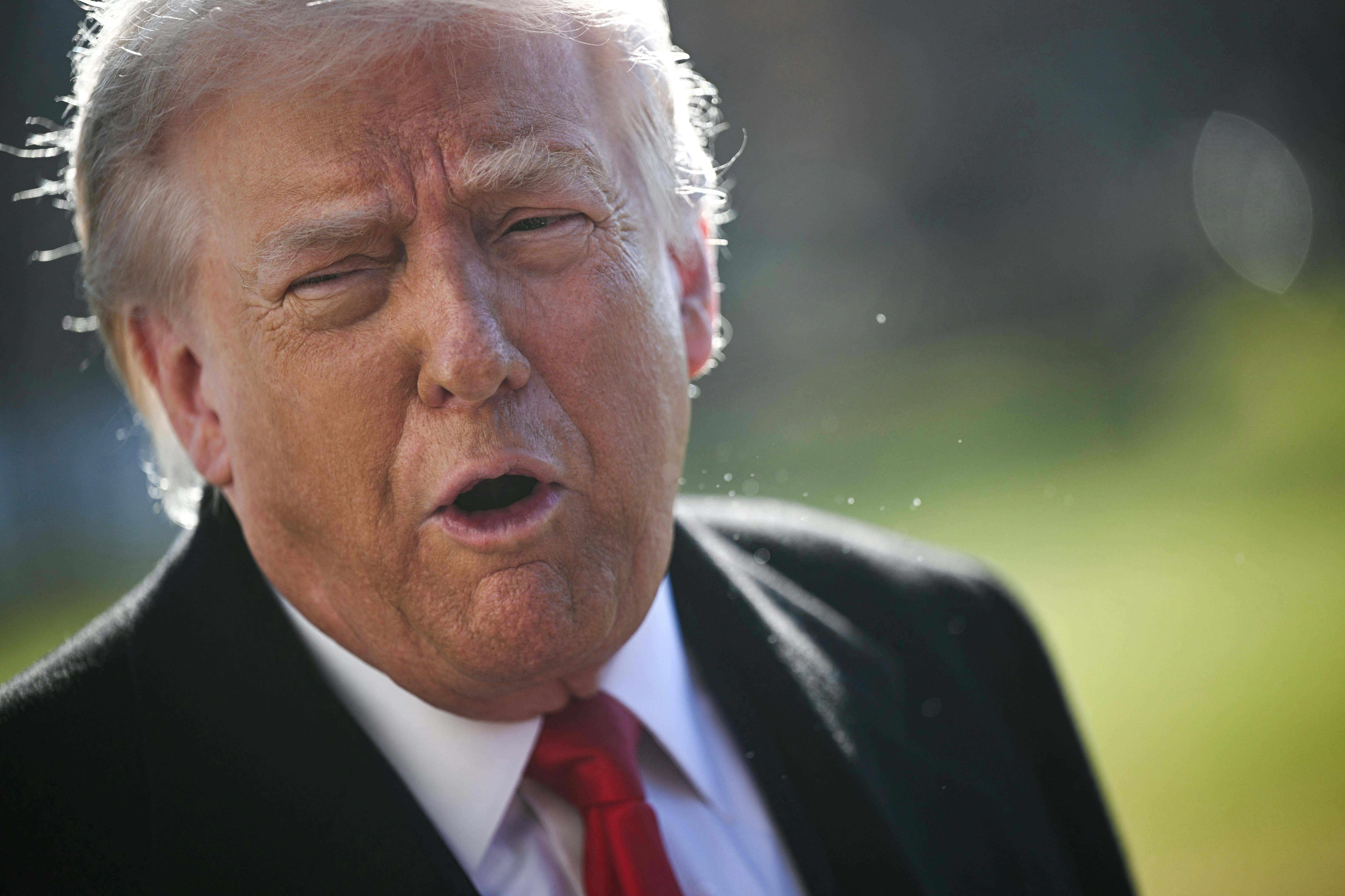 Donald Trump speaks while standing outside the White House
