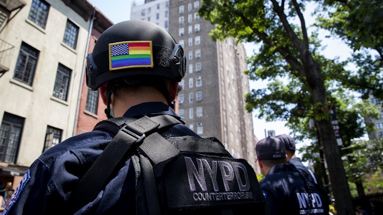 A police officer, with a rainbow American flag on the back of his helmet, watches the Pride parade in New York City 
