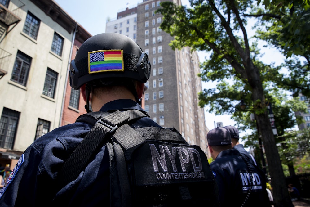 A police officer, with a rainbow American flag on the back of his helmet, watches the Pride parade in New York City