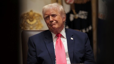 Donald Trump smiles while sitting in a Cabinet meeting