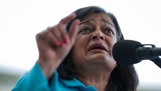 Representative Pramila Japayal gestures while speaking into a microphone