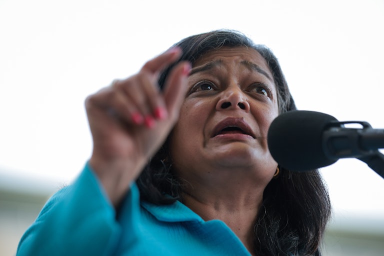 Representative Pramila Japayal gestures while speaking into a microphone