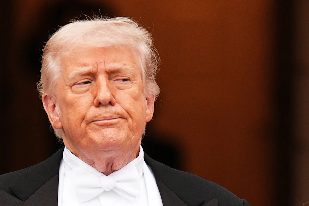 Donald Trump presses his lips together and looks to the side while standing outside the White House