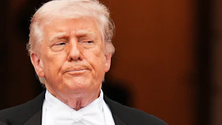 Donald Trump presses his lips together and looks to the side while standing outside the White House