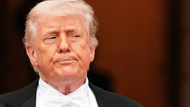 Donald Trump presses his lips together and looks to the side while standing outside the White House