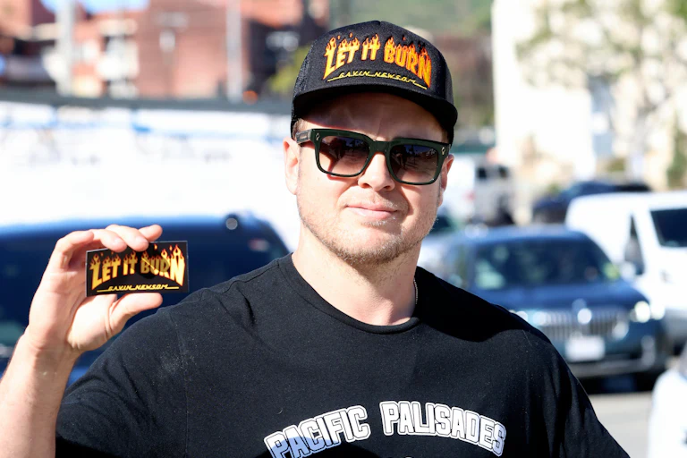 Spencer Pratt holds up a card reading "Let it Burn"