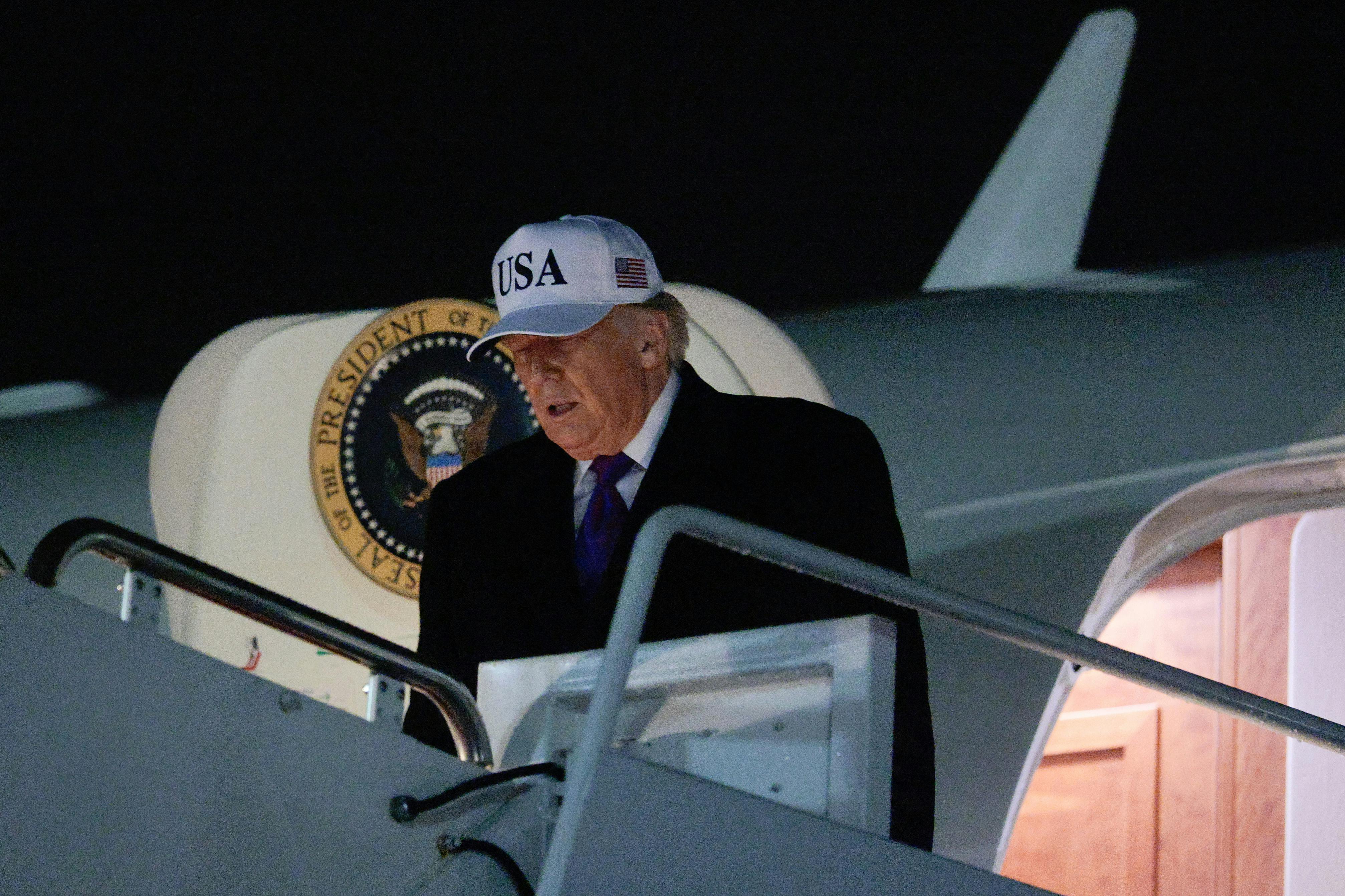 Donald Trump looks down while walking out of Air Force One