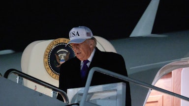Donald Trump looks down while walking out of Air Force One