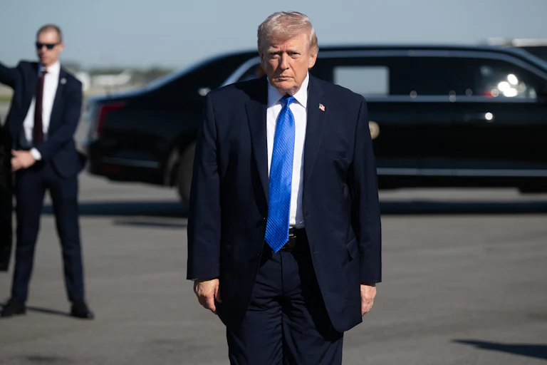 Donald Trump stands on an airport tarmac