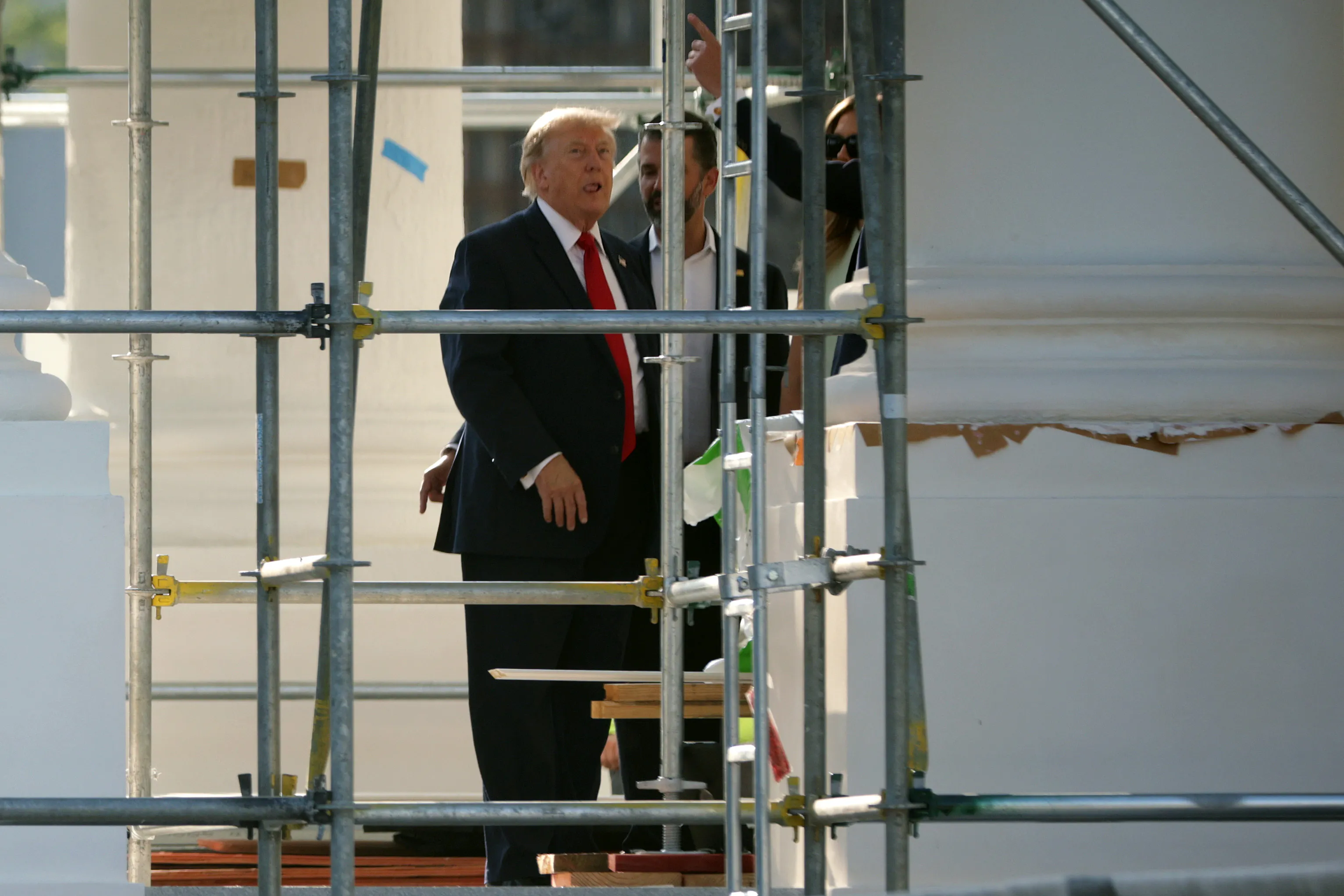 Donald Trump sticks his tongue out while touring the construction on the White House