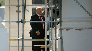 Donald Trump sticks his tongue out while touring the construction on the White House